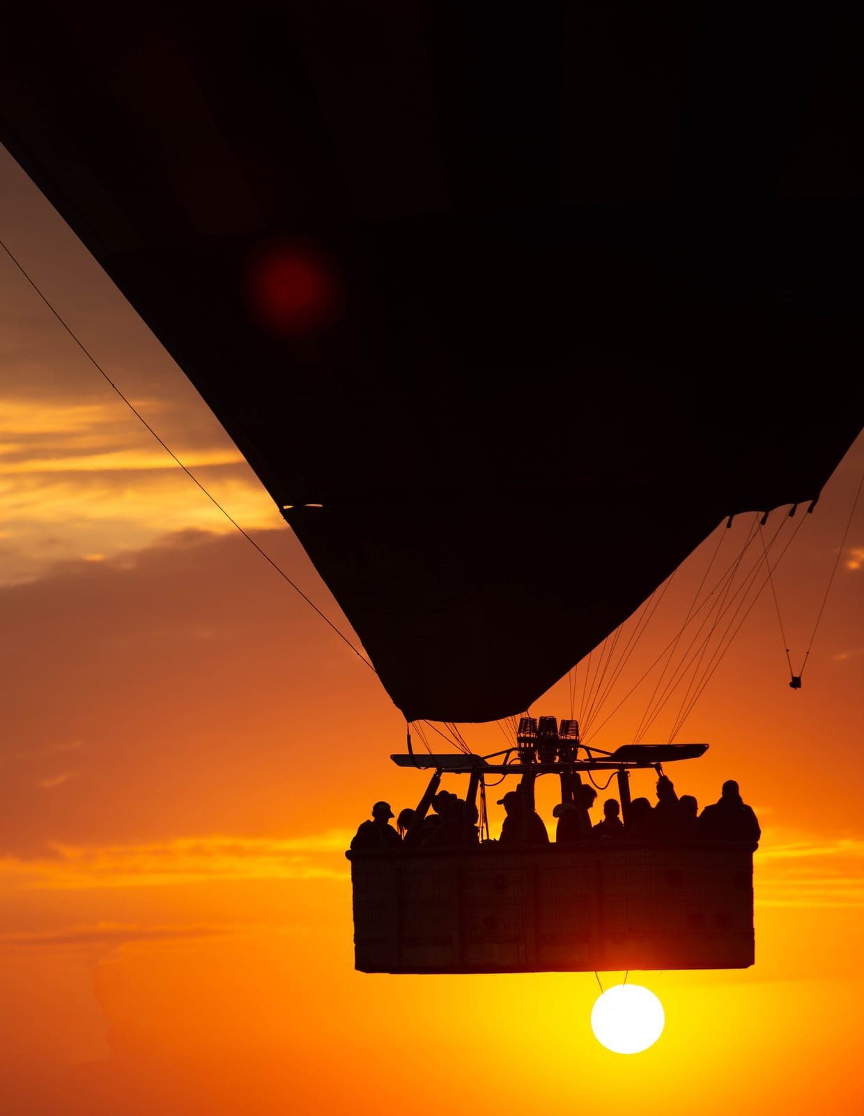 Balloon passengers silhouetted against the sunrise