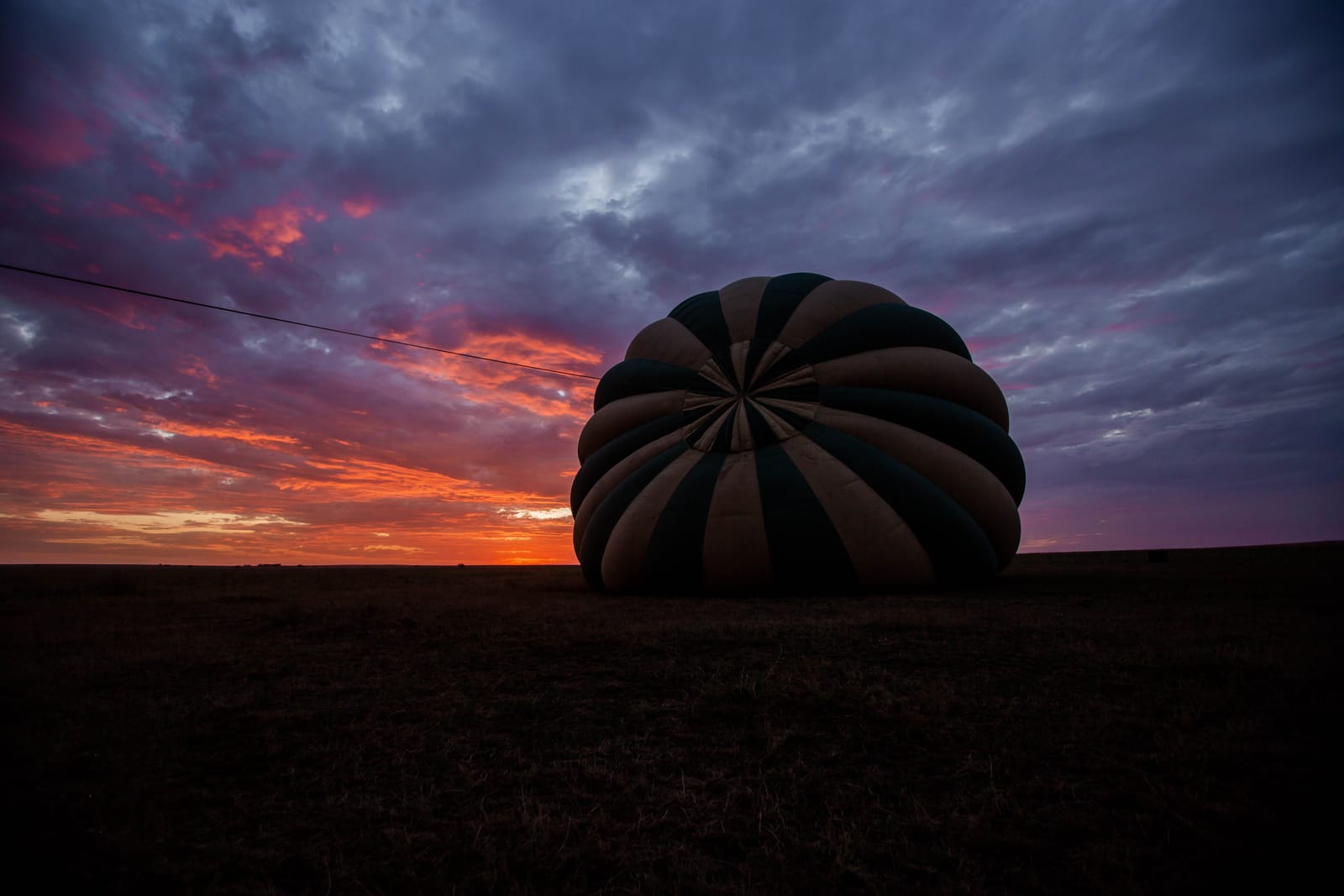 A hot-air balloon inflating on the Serengeti before dawn