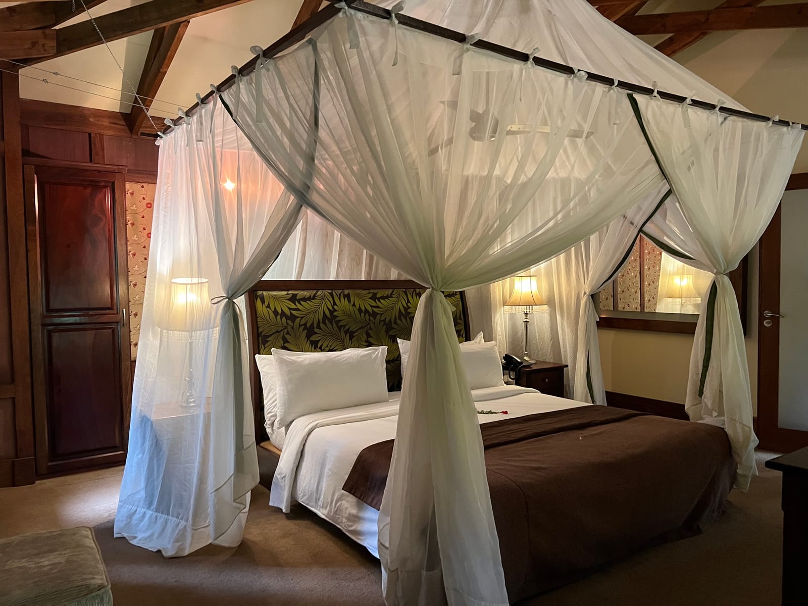 A canopied bed in a safari lodge room