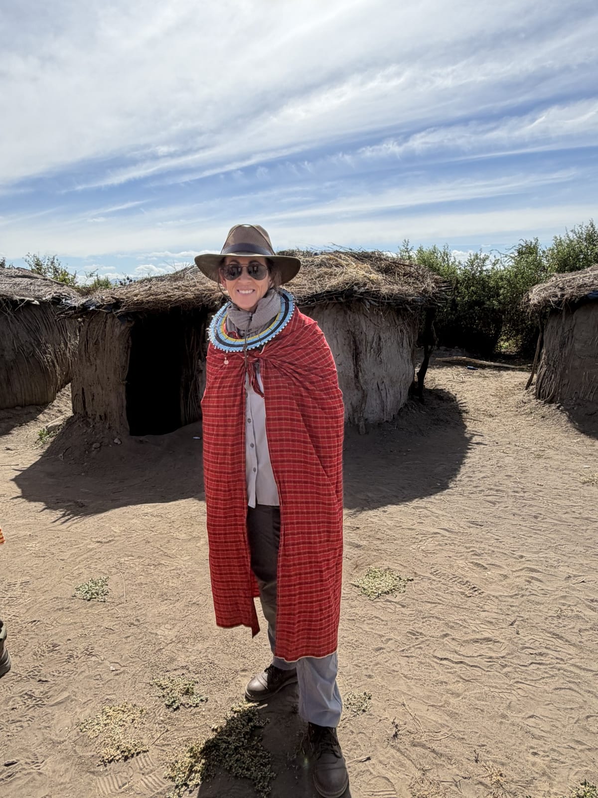 Nancy wrapped in a red Maasai shuka in a village